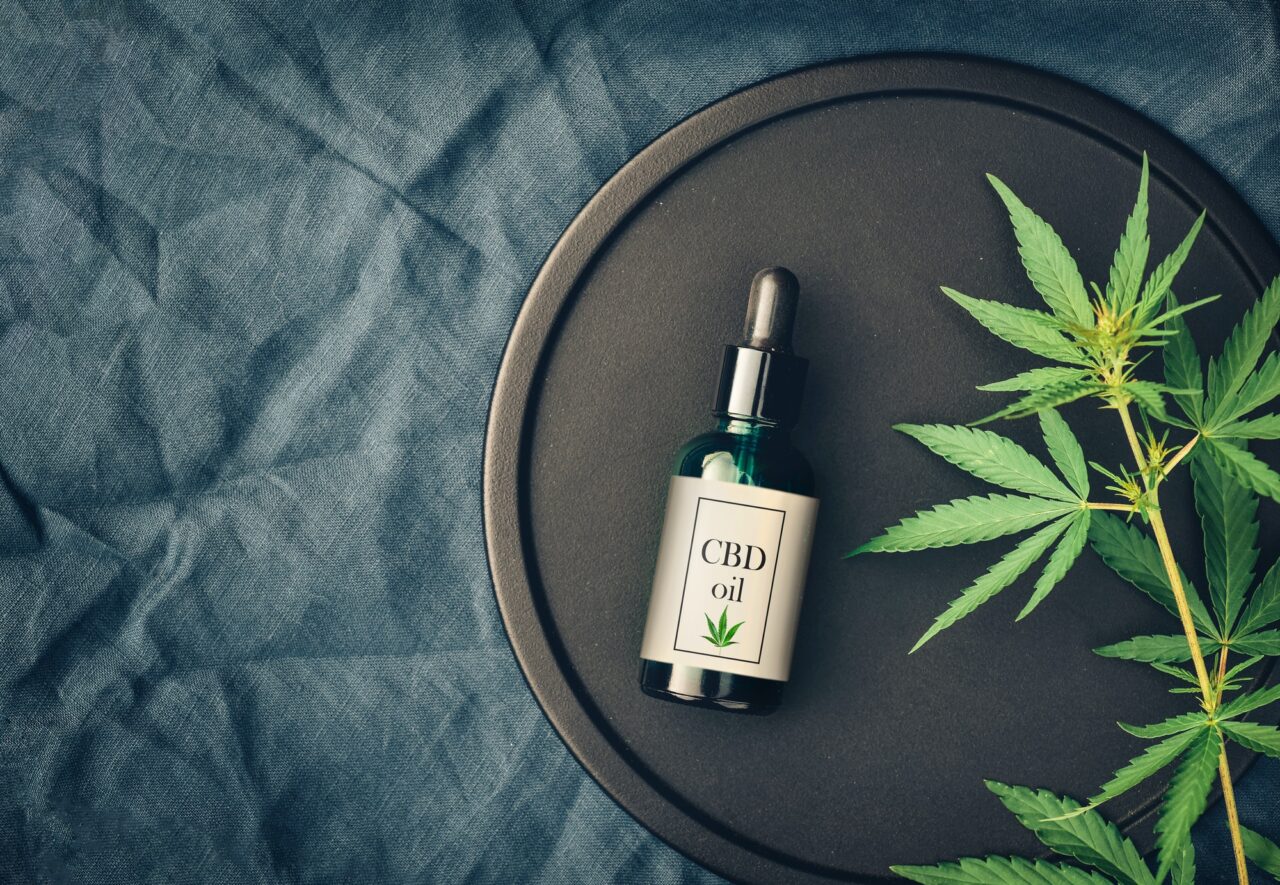 Medical marijuana cannabis products CBD oil and hemp leaves on dark background